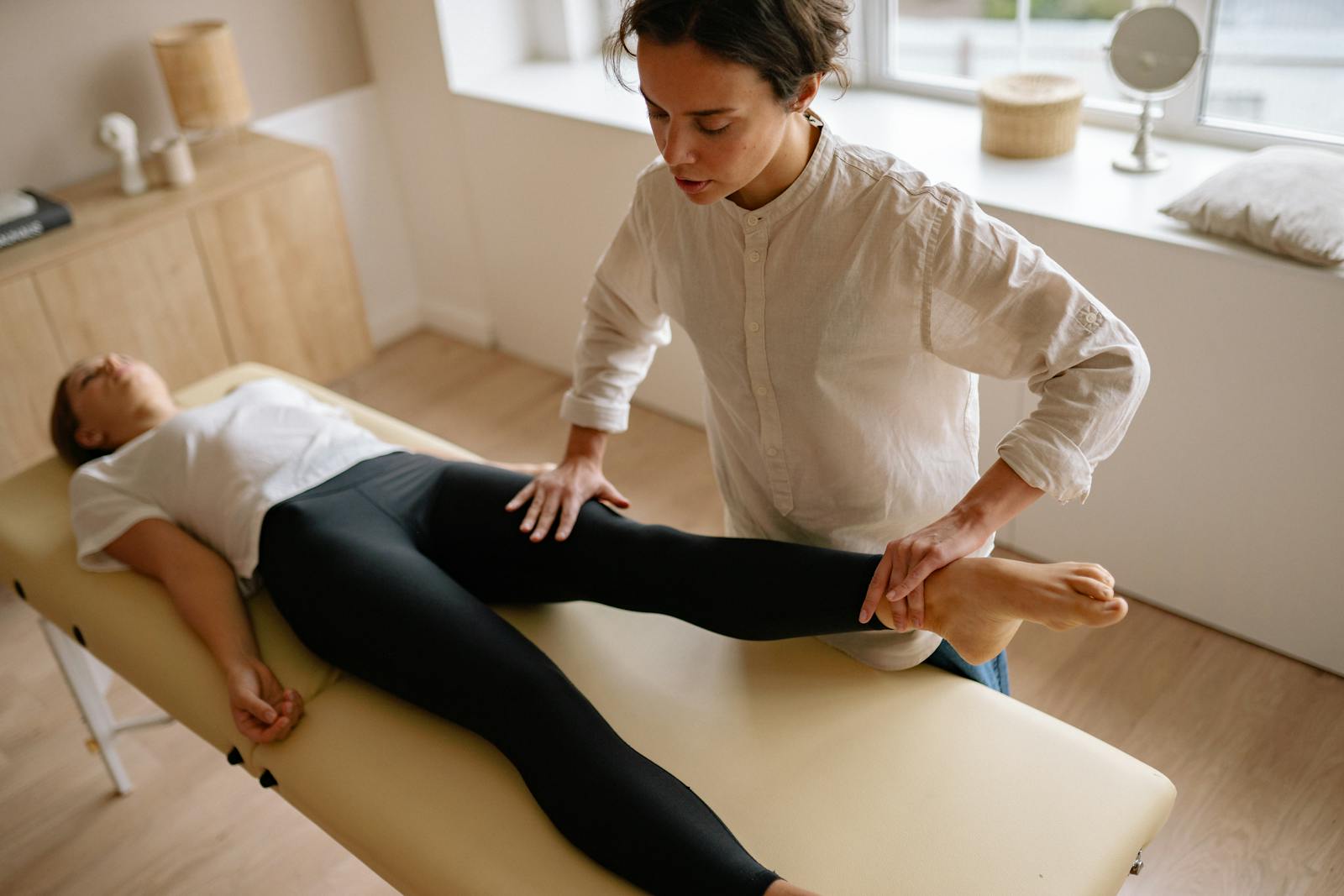 Physiotherapist Holding Womans Leg 